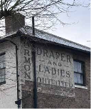 Side of a building with traces of an old sign showing through