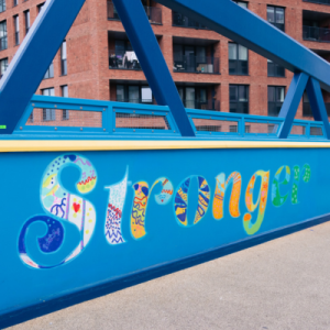 The word Stronger painted on a blue bridge