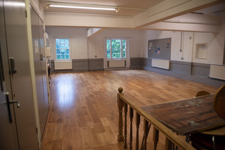 An empty room with dark wooden floorboards with white and grey walls