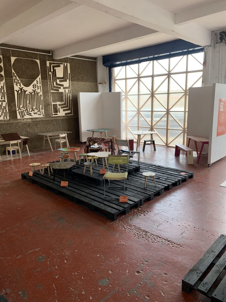 Chairs and small tables scattered around a room with a red floor and brown walls