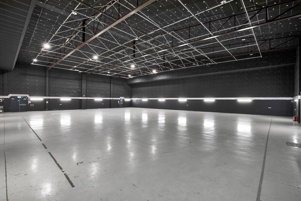 a large empty film stage in black and white with lights lighting an open space