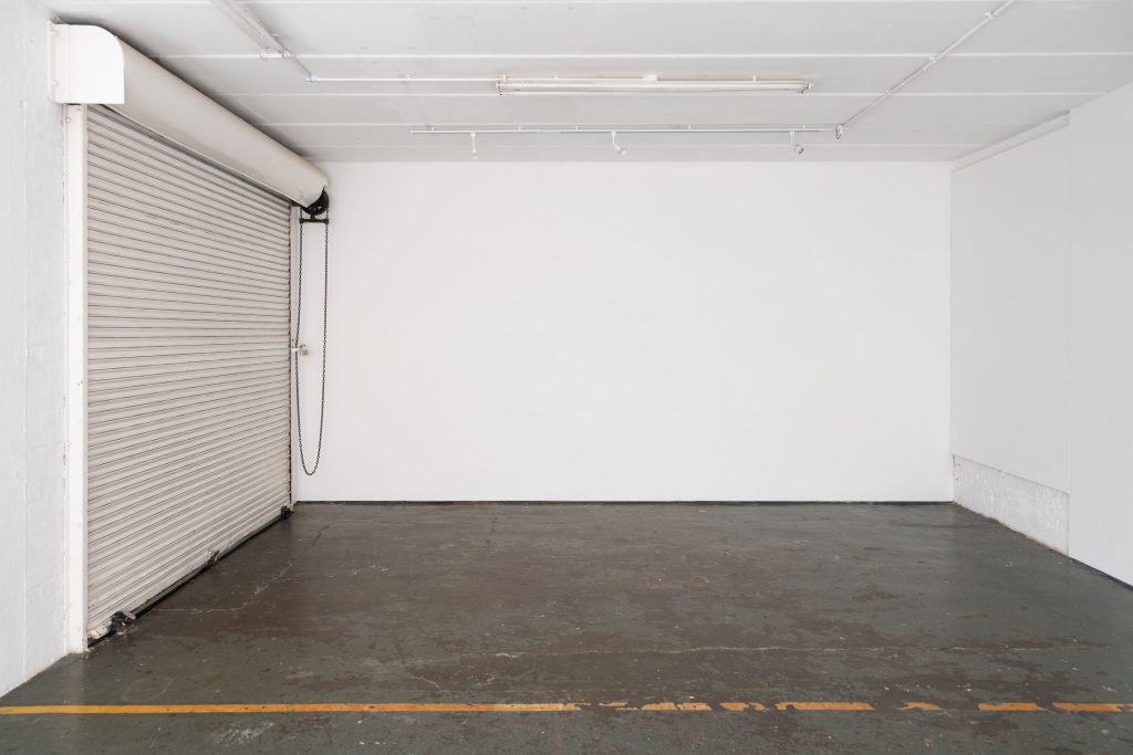 An empty room with hard, wooden floor and white walls and ceiling.
