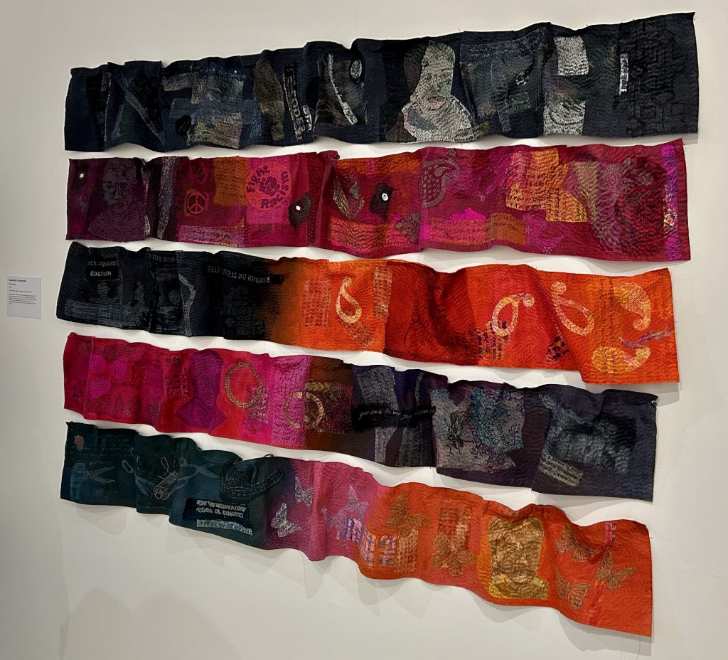 Five lines of colourful fabrics on a white wall