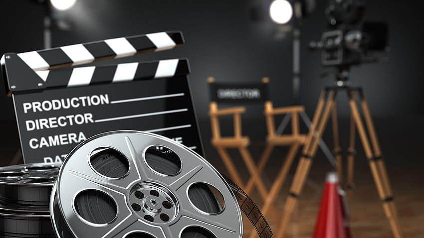 Various iconic filming tools in a studio - a can of film, a clapboard, a directors chair and a camera on a tripod