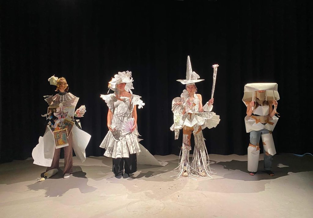Four people dressed up on a stage