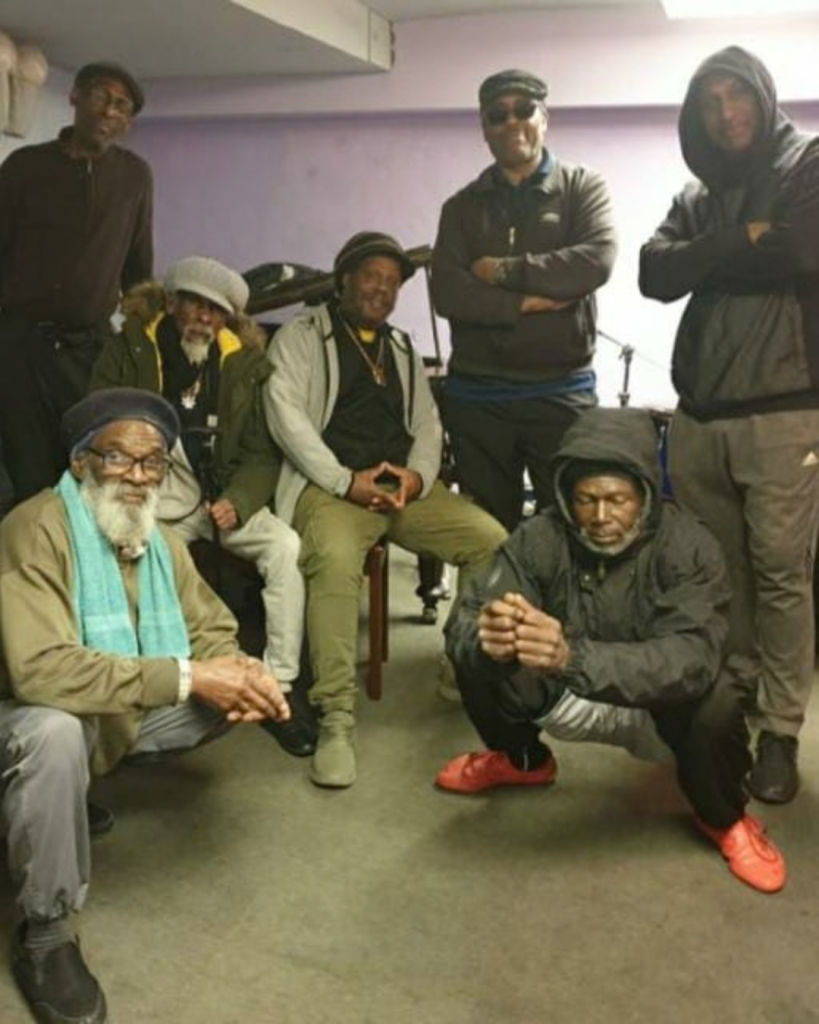 Seven men in casual clothing posing for the camera